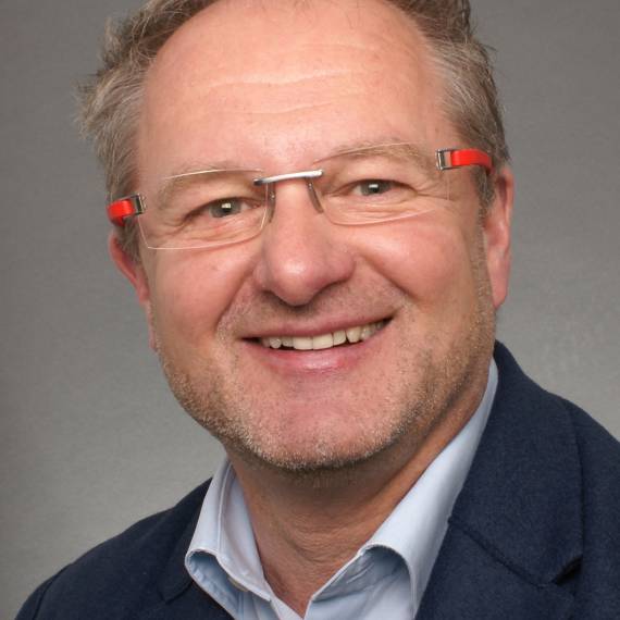 dup Ein Mann der in die Kamera lächelt.