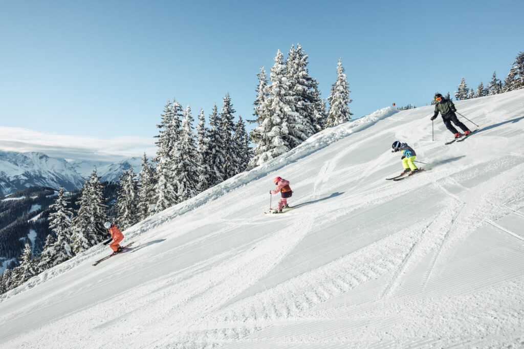 A family skiing on a slope at Schmittenhöhe in Zell am See