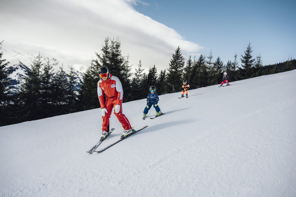 Ski instructors with children during a ski lesson on the slopes in Zell am See-Kaprun